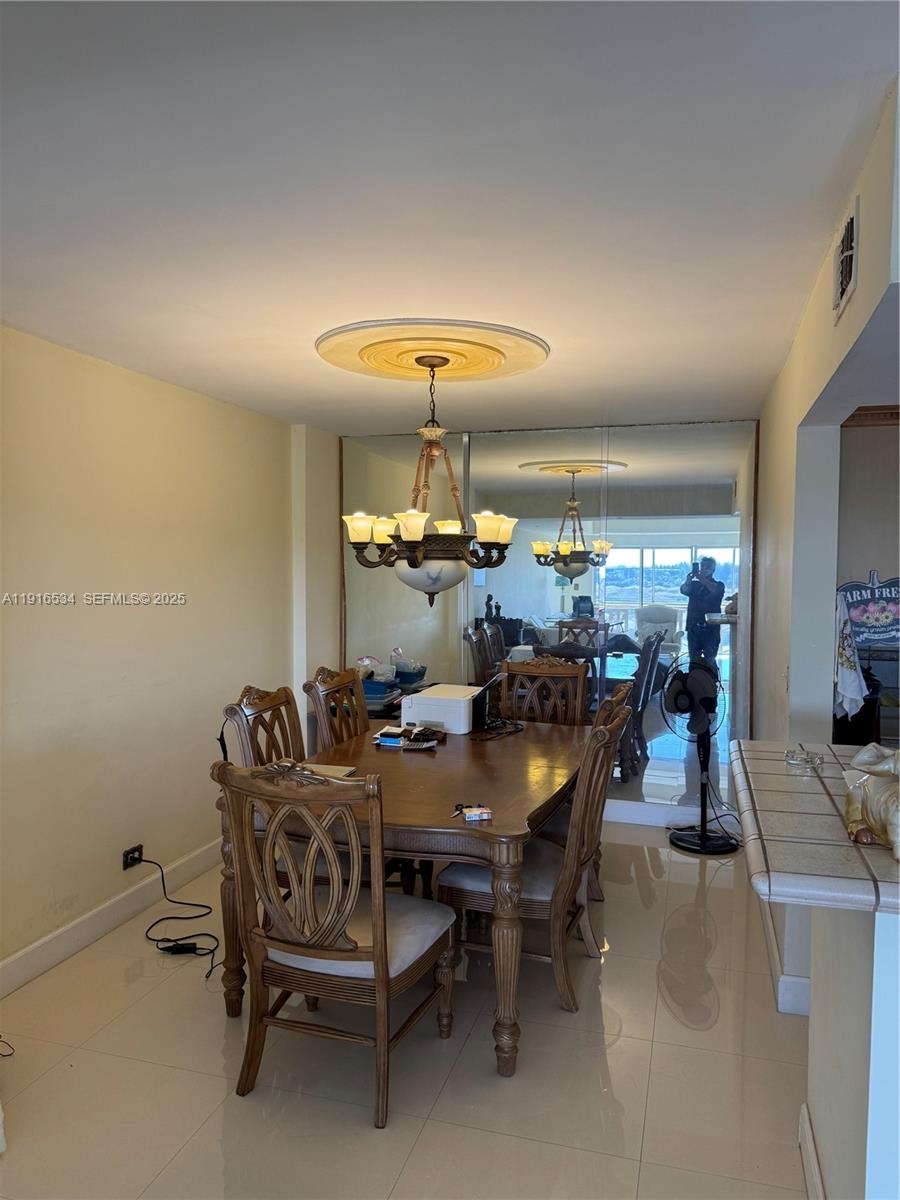 800 Northeast 195th Street, Unit 714 Miami, FL 33179 - Photo 11 of 17 a view of a dining room with furniture and chandelier
