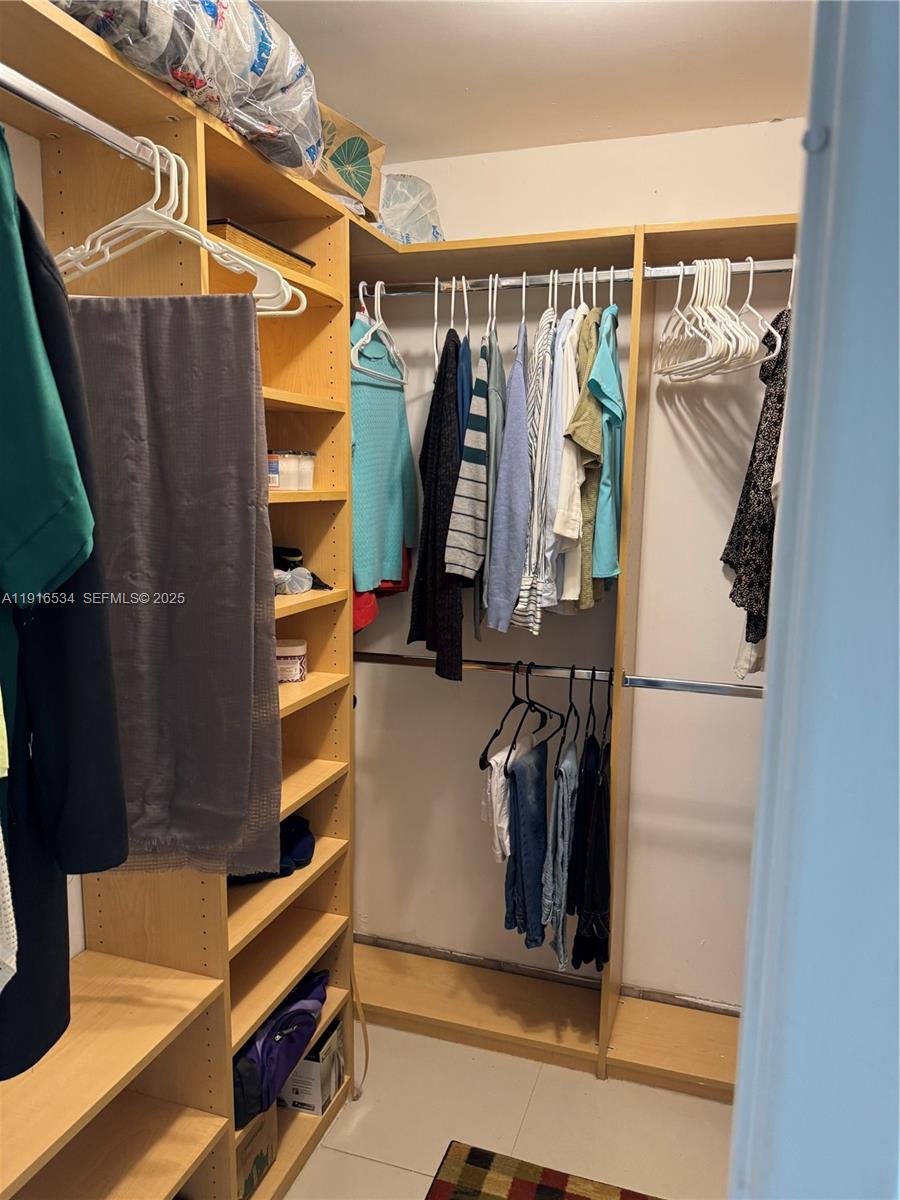 800 Northeast 195th Street, Unit 714 Miami, FL 33179 - Photo 14 of 17 a view of walk in closet with clothes and shoes
