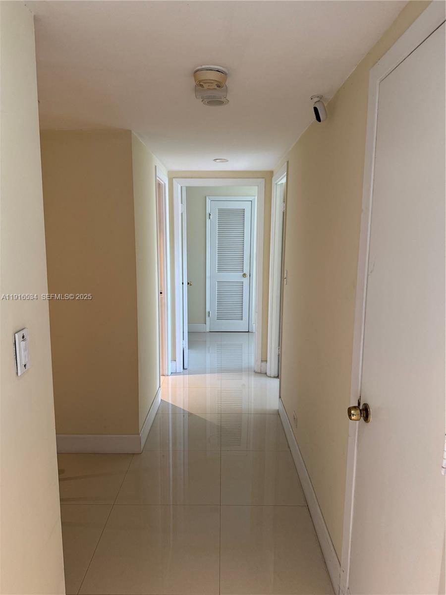800 Northeast 195th Street, Unit 714 Miami, FL 33179 - Photo 15 of 17 a view of a hallway with wooden shelves