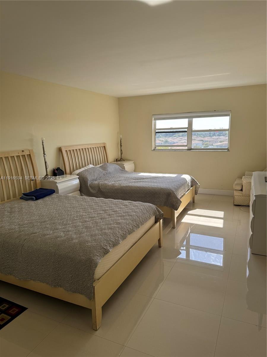 800 Northeast 195th Street, Unit 714 Miami, FL 33179 - Photo 16 of 17 a bedroom with a bed and window