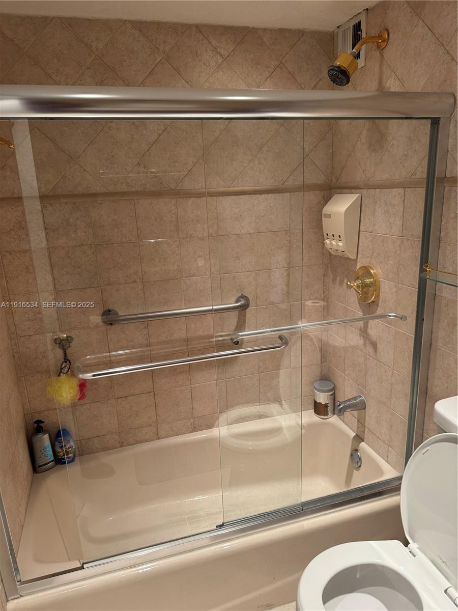 800 Northeast 195th Street, Unit 714 Miami, FL 33179 - Photo 2 of 17 a bathroom with a bathtub and a shower