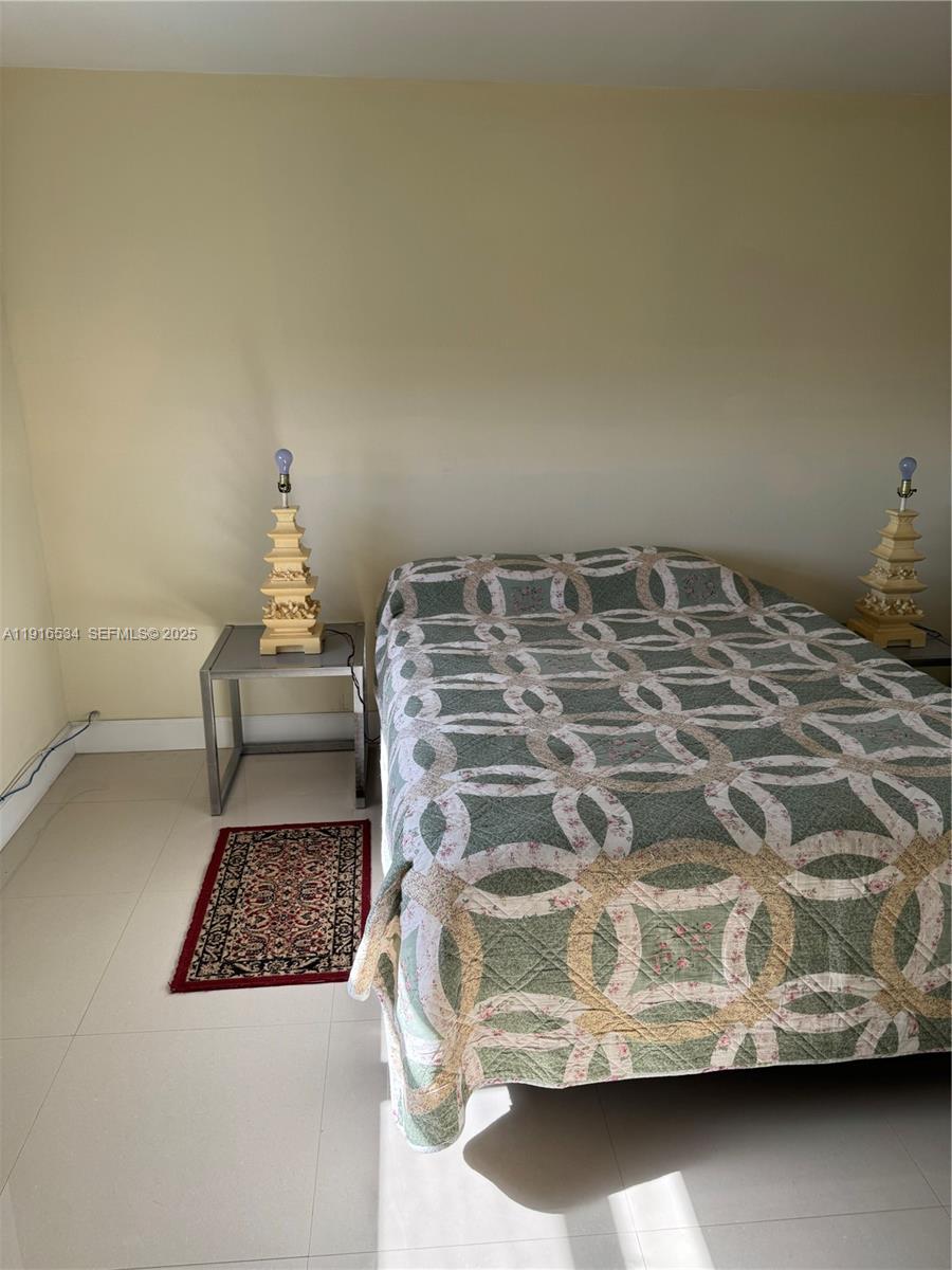 800 Northeast 195th Street, Unit 714 Miami, FL 33179 - Photo 7 of 17 a bedroom with a bed and a window