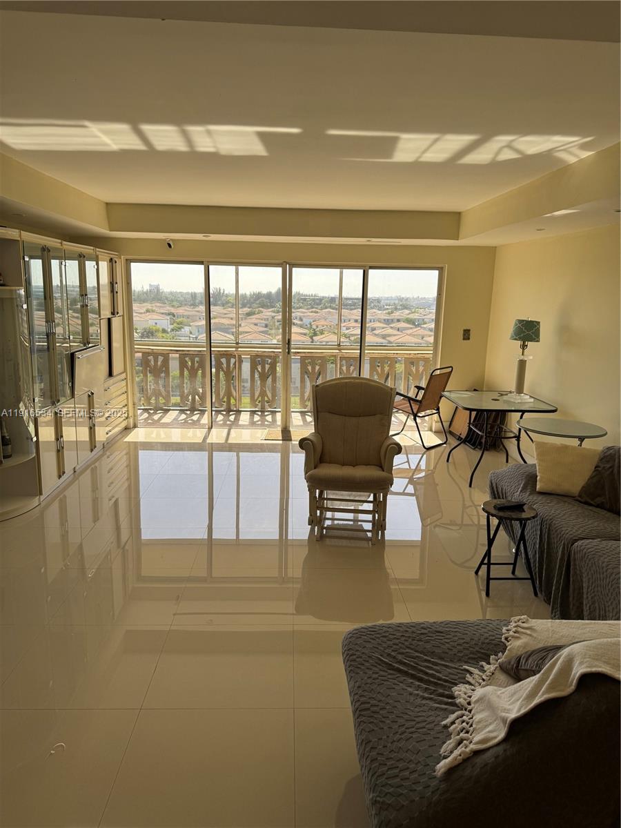 800 Northeast 195th Street, Unit 714 Miami, FL 33179 - Photo 10 of 17 a living room with furniture and a large window