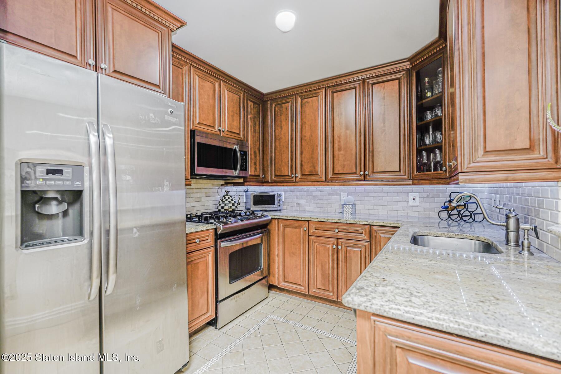 155 Bay Street, Unit 2L Staten Island, NY 10301 - Photo 16 of 32 a kitchen with stainless steel appliances granite countertop a stove a sink and a microwave