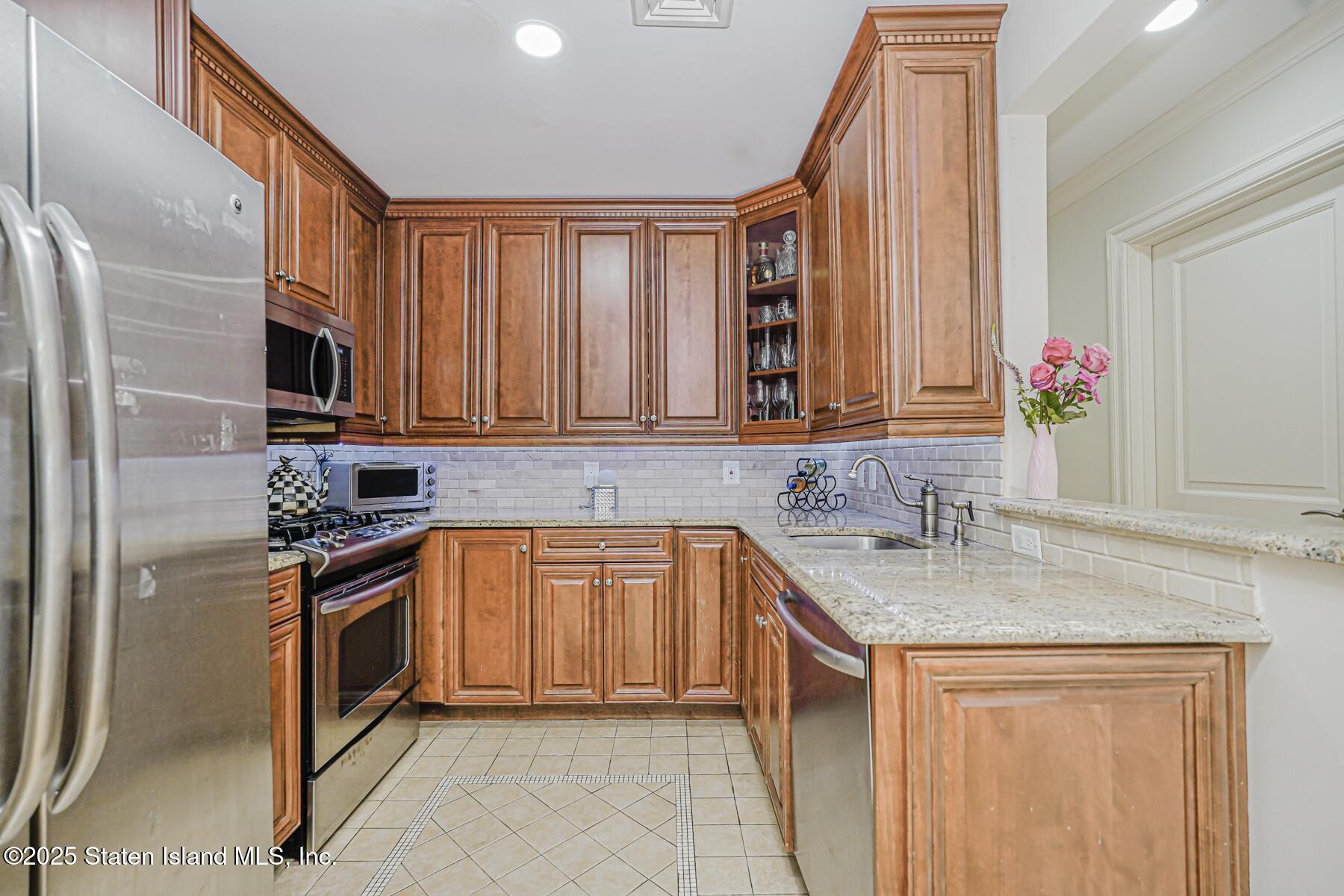 155 Bay Street, Unit 2L Staten Island, NY 10301 - Photo 17 of 32 a kitchen with stainless steel appliances granite countertop a sink stove and refrigerator