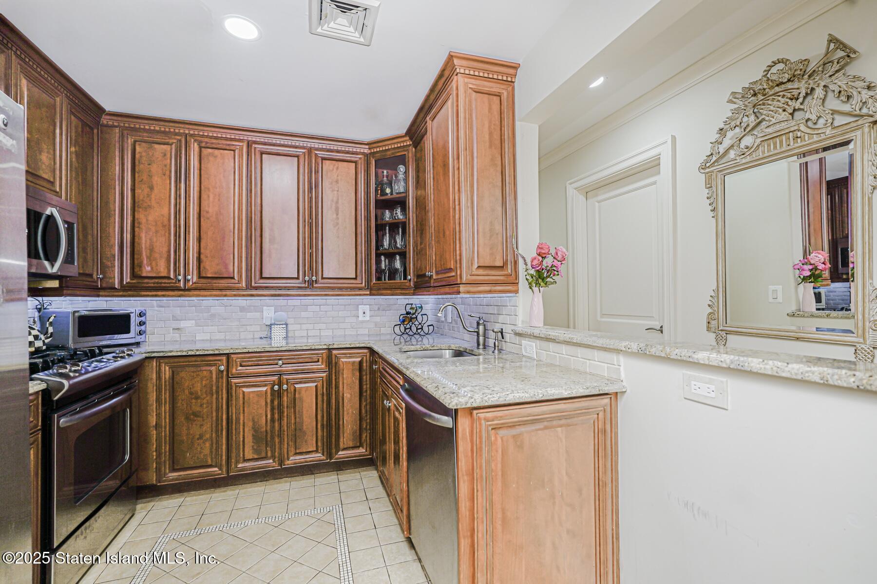155 Bay Street, Unit 2L Staten Island, NY 10301 - Photo 18 of 32 a kitchen with stainless steel appliances granite countertop a sink stove and cabinets