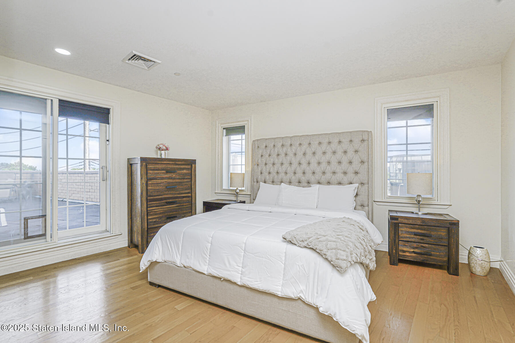 155 Bay Street, Unit 2L Staten Island, NY 10301 - Photo 22 of 32 a bedroom with a bed and dresser with wooden floor