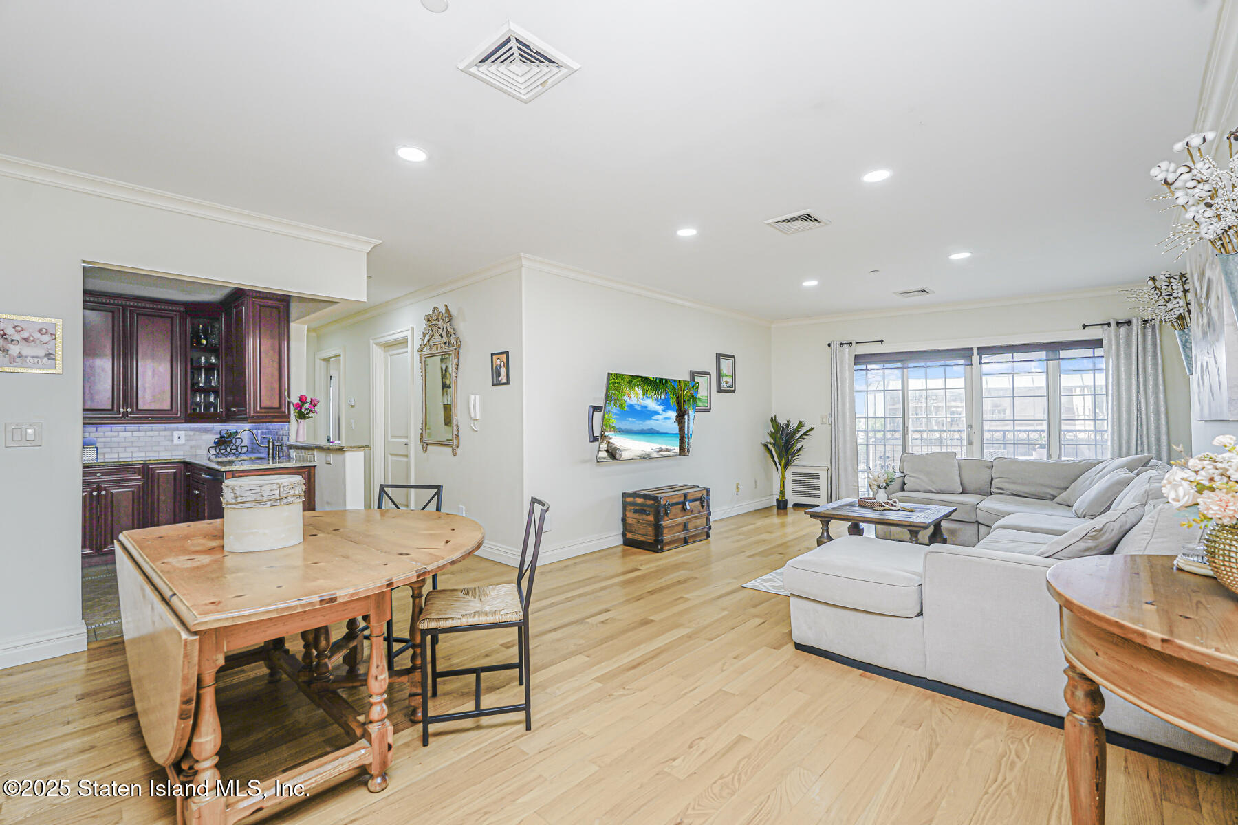 155 Bay Street, Unit 2L Staten Island, NY 10301 - Photo 8 of 32 a living room with furniture a wooden floor and a flat screen tv