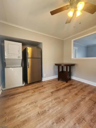 a view of an empty room with a window and kitchen