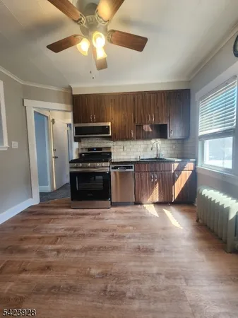 a kitchen with kitchen island granite countertop a stove cabinets and refrigerator