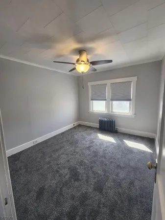 en empty room with windows and chandelier fan