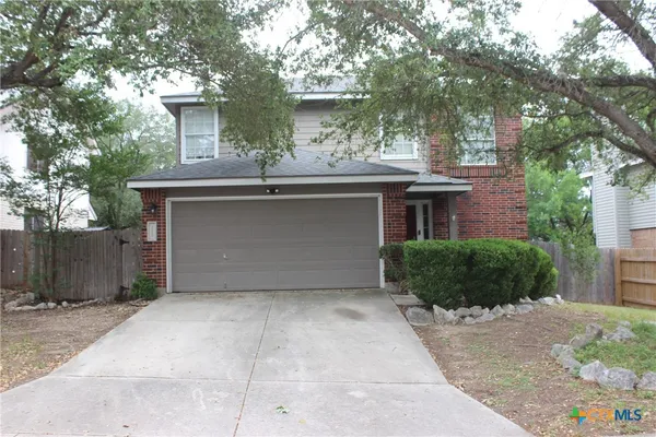 a front view of a house with a garden and plants