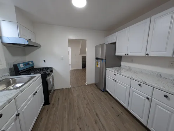 a kitchen with granite countertop a sink dishwasher stove and cabinets