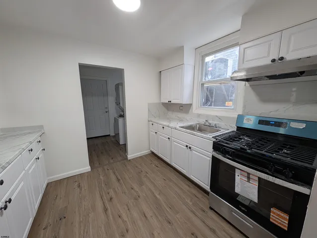 a kitchen with a stove and a wooden floor