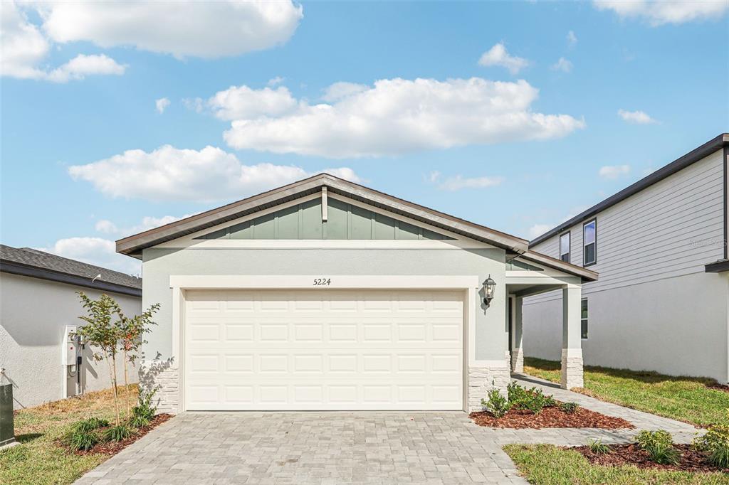a front view of a house with a yard and garage
