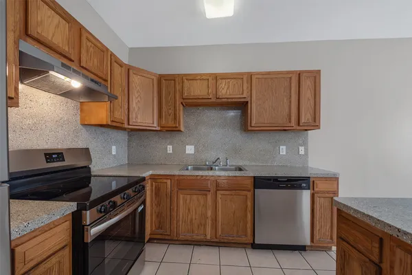 a kitchen with stainless steel appliances granite countertop a sink and a stove