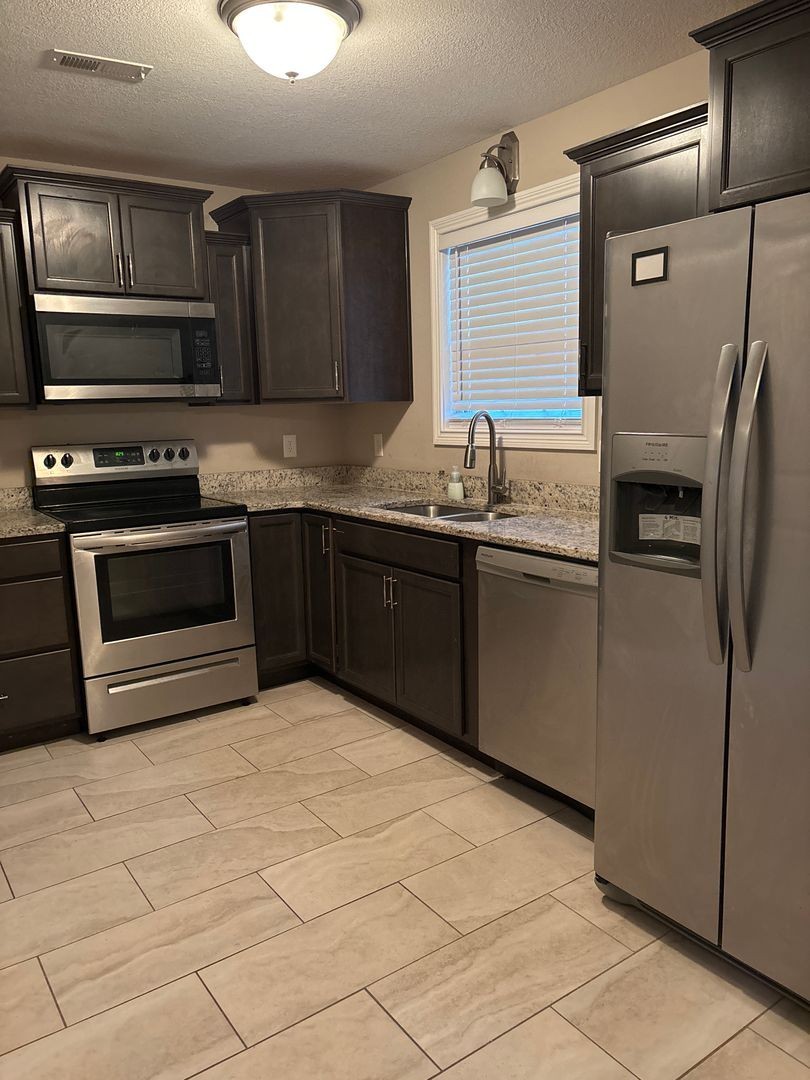 119 Ambridge Street Oak Grove, KY 42262 - Photo 4 of 12 a kitchen with stainless steel appliances granite countertop a sink and a stove