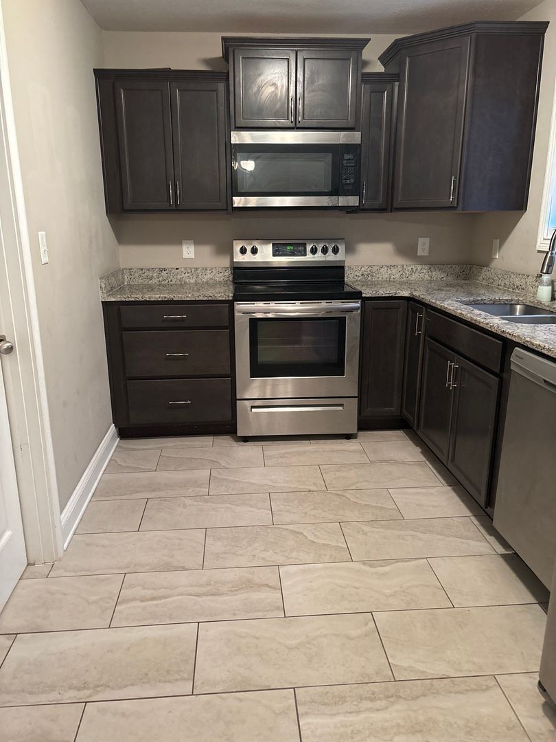 119 Ambridge Street Oak Grove, KY 42262 - Photo 5 of 12 a kitchen with stainless steel appliances granite countertop a stove and a refrigerator