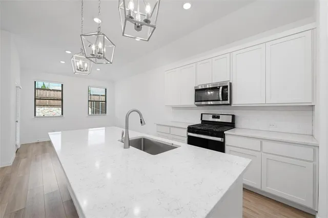a kitchen with stainless steel appliances a stove microwave and white cabinets