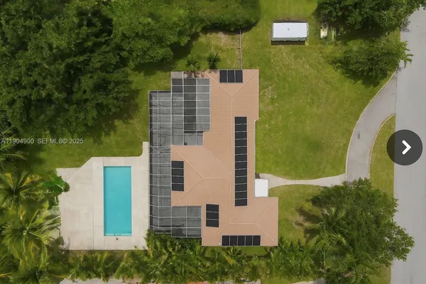 an aerial view of residential houses with outdoor space and swimming pool