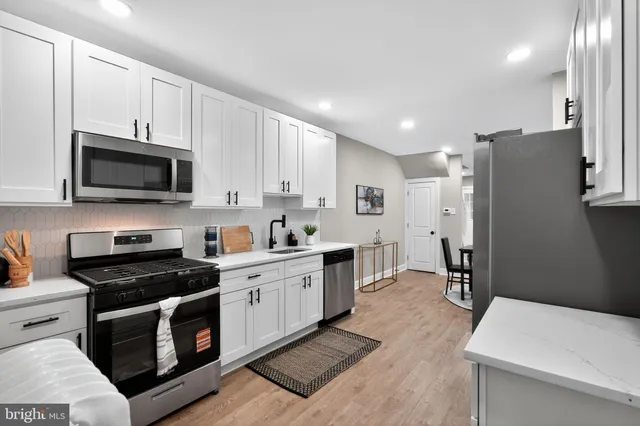 a kitchen with stainless steel appliances a stove a sink and a refrigerator