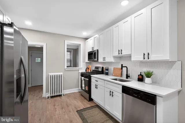 a kitchen with stainless steel appliances granite countertop a refrigerator sink and white cabinets