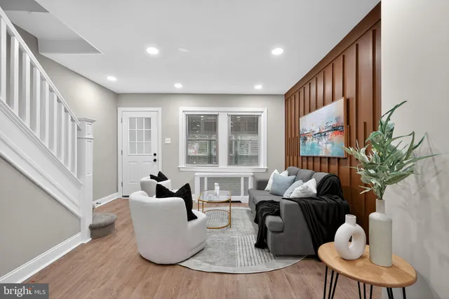 a living room with furniture and a large window with wooden floor