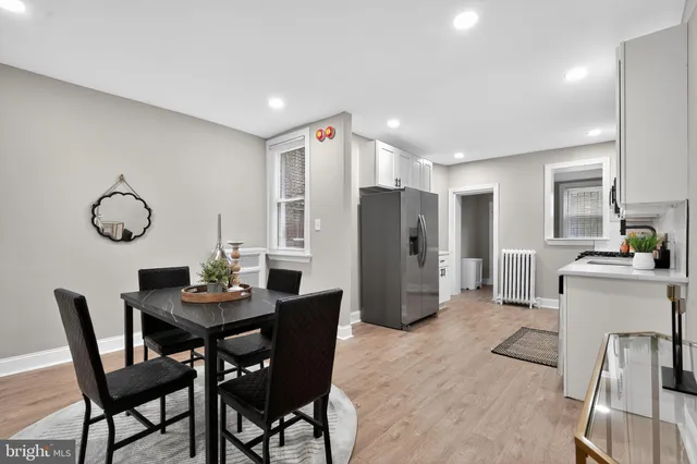 a kitchen with stainless steel appliances kitchen island granite countertop a table chairs and a refrigerator