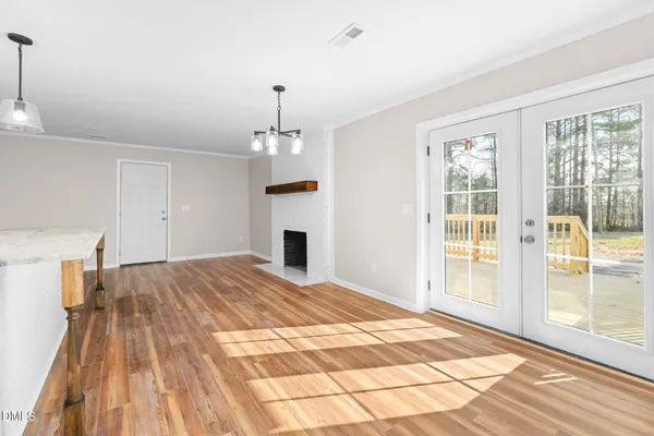 an empty room with wooden floor ceiling fan and windows