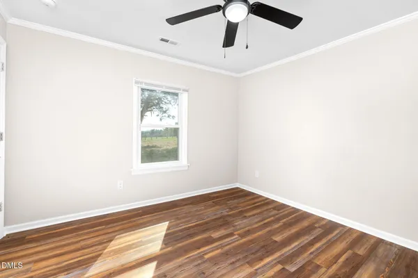 a view of empty room with wooden floor