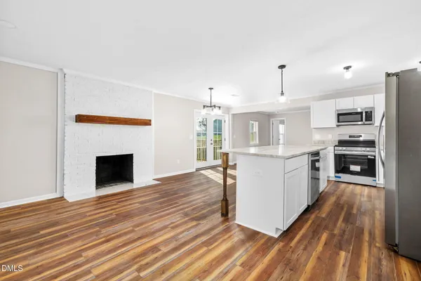a kitchen with kitchen island white cabinets and stainless steel appliances
