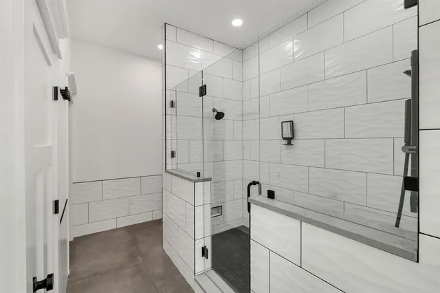 a spacious bathroom with double vanity sink a two mirror a window and a bathtub