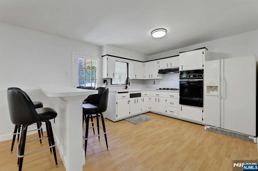 20 Blue Hill Road Norwood, NJ 07648 - Photo 32 of 49 a kitchen with stainless steel appliances a stove a refrigerator cabinets and a dining table