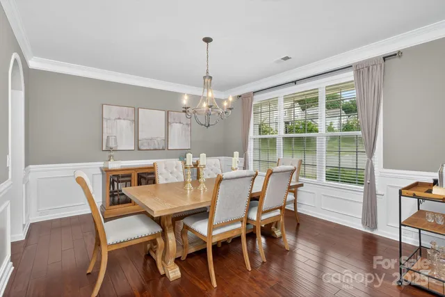 a living room with furniture kitchen view and a chandelier