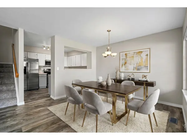 a view of a kitchen with refrigerator and wooden floor