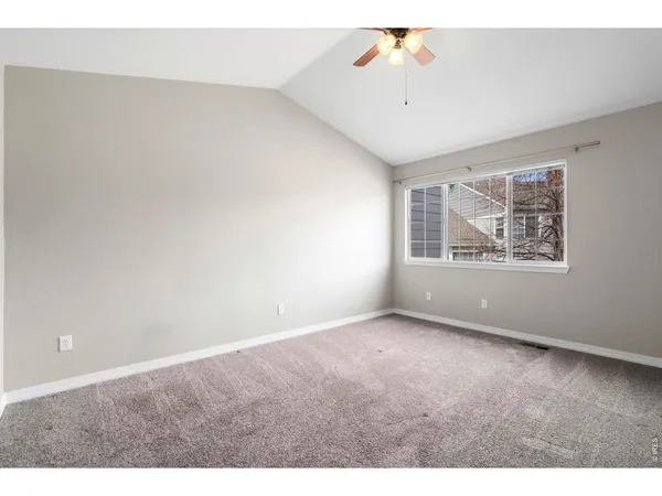 a view of an empty room with a ceiling fan