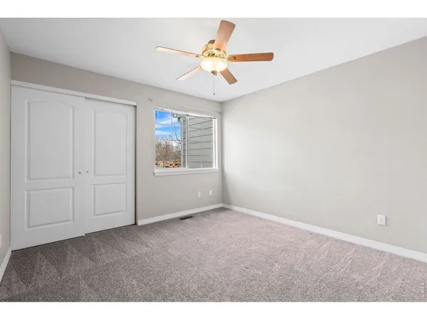 a view of an empty room and a ceiling fan