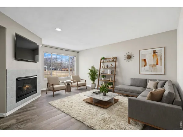 a view of wooden floor fire place and windows in a room