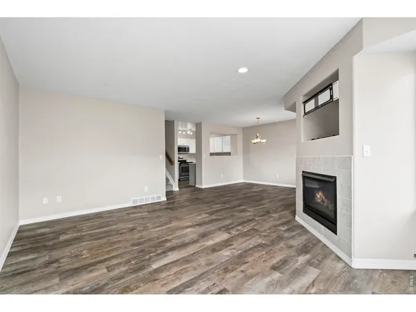 a view of an empty room with a fireplace and a window