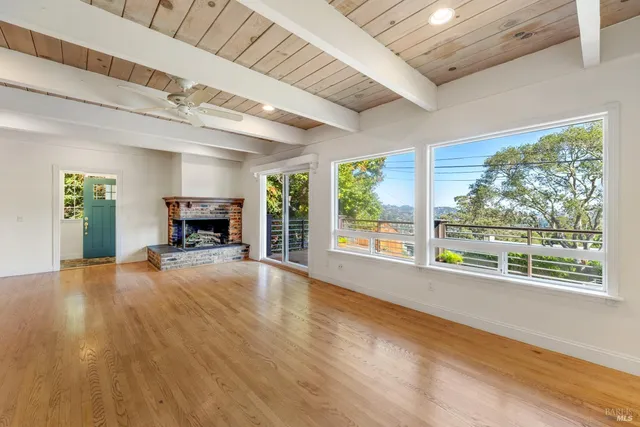 a view of empty room with wooden floor and fireplace