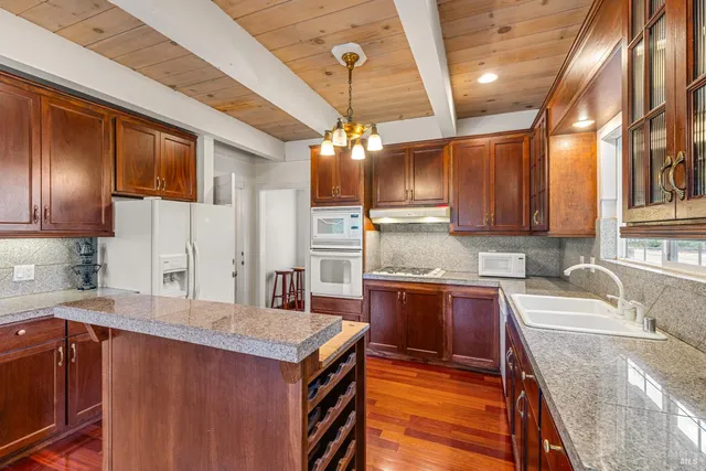 a kitchen with granite countertop a sink stove and cabinets
