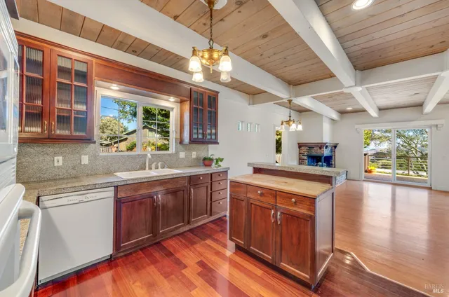 a kitchen with stainless steel appliances granite countertop sink stove and wooden cabinets