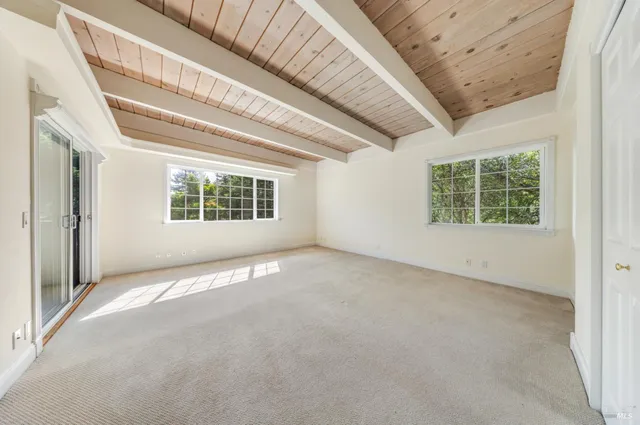 an empty room with a windows and ceiling fan