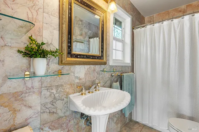 a bathroom with a sink and mirror with bathtub