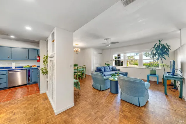 a view of a living room kitchen with furniture and a wooden floor