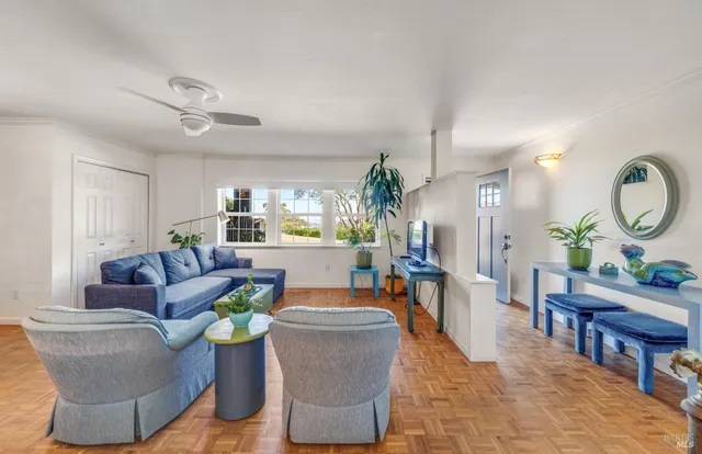 a living room with furniture a mirror and wooden floors