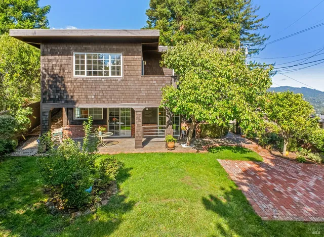 a view of a patio with table and chairs and potted plants and large trees