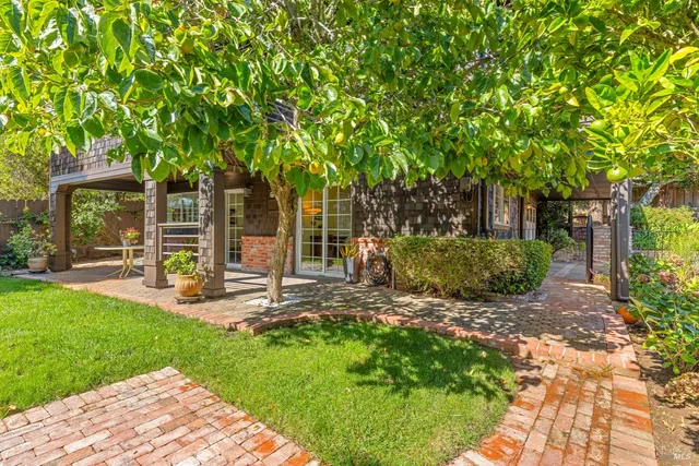 a view of a chair and table in backyard of the house