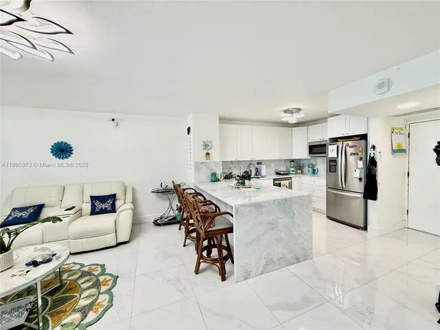 a living room with furniture and kitchen view