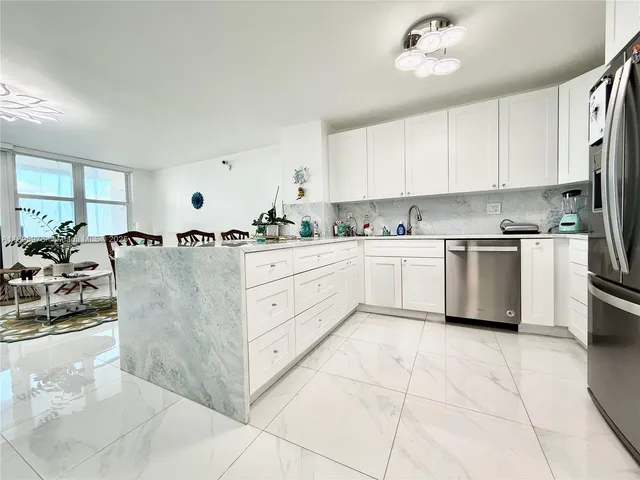 a kitchen with white cabinets and sink
